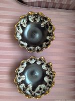 Top view showing both bowls, scalloped shape, black glaze, white speckles, gold rim
