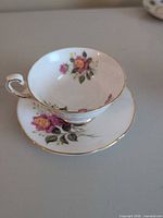 Teacup on saucer showing floral pattern and gold trim