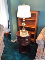 Full view of round wood side table with lamp on top