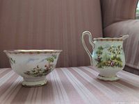 Side profile of creamer and sugar bowl showing exterior pattern and form