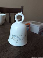 Front view of porcelain bell showing floral design and overall shape