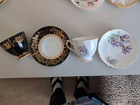 Two teacups and two saucers laid out showing both patterns