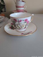 Teacup on saucer showing floral pattern and gilt rim
