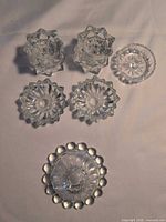 Top view of all six clear pressed glass candle holders