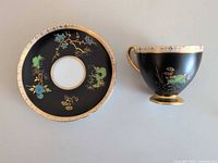 saucer front and cup profile displaying floral motif and gilt