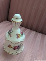 Front view of floral bone china bell showing pattern and gold trim