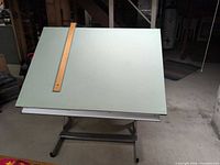 Front view of drafting table showing laminate surface and straightedge