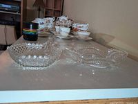 Front view of both clear pressed glass bowls on table