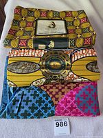 Stacked folded fabrics showing labels and patterns, lot tag visible
