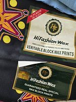 Close-up of HiFashion Wax labels on black ground star print fabric