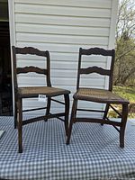 Two antique wooden side chairs on table outdoors