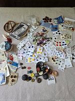 Full lot laid out showing cards of buttons, loose buttons, ribbons and fasteners