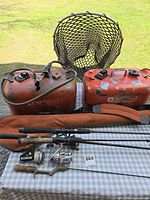 Overall lot showing rods with reels, two orange fuel tanks, landing net, rod case, small tackle items