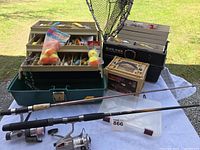 Wide view of rods, reels, tackle boxes, lures and net