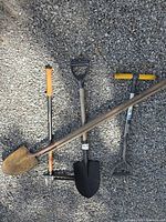 All four garden tools laid on gravel
