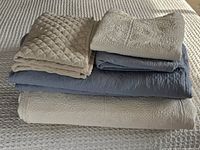 Stack of both coverlets and pillow shams folded