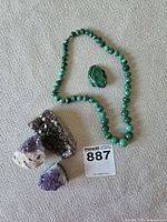 Necklace, frog carving, three amethyst clusters grouped