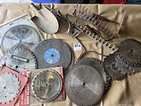 Overview of saw blades, abrasive discs, shovel head and rake heads on table