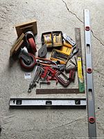 Full lot view with levels, casters, bit sets, clamps, wrenches, scraper, rulers