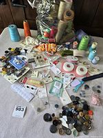 Full lot with thread, buttons and notions spread on table