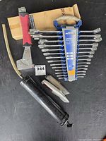 Group shot of all tools: wrench set, grease gun, staple gun, utility knives