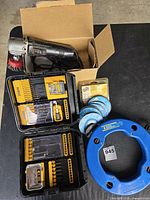 Full lot: fish tape, angle grinder in box, Dewalt bit kit open, cut-off wheels, small driver bit packs