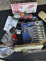 Overview of all items including multitool, wrench set, staple hammer, brush head, bits and hardware