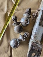 Overview of three trailer hitch balls, hitch mount end and tape measure for scale