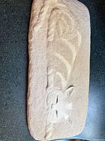 Front view of beige plaster cat wall plaque