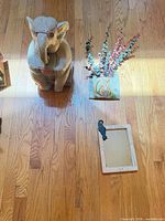 Ceramic elephant statue, cat wall pocket planter with faux greenery, small mirror with cat hook displayed on wood floor