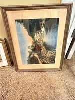 Large framed landscape river scene with rock-lined bank