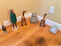 Six figurines arranged on hardwood floor showing overall lot