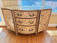 Front view of bowed chinoiserie dresser showing drawers, doors, painted design and legs