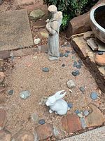 Overhead view of both concrete statues in garden setting
