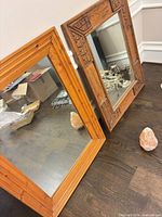 Both mirrors leaning against wall on hardwood floor