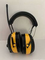 Front view of 3M WorkTunes headset showing padded headband, yellow ear cups and antenna