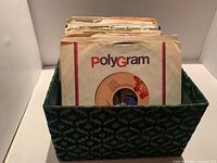 Front view of patterned fabric box filled with sleeved 45 RPM records, PolyGram sleeve visible