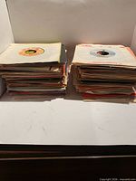 Two stacks of approximately 120 sleeved 45 RPM records