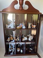 Front view of cabinet showing figurines on shelves