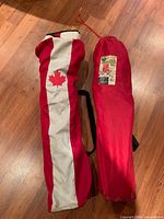 Two carry bags, one red/white maple leaf, one solid red