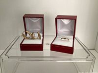 Both red boxes displayed open: hoop earrings in left box, ring in right box