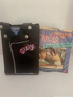 DVD in faux leather jacket slipcase beside 45 RPM record sleeve