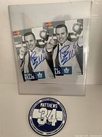 Two signed Ron Ellis photos and signed Auston Matthews coaster displayed together