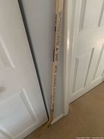 Full view of wooden souvenir hockey stick leaning against wall