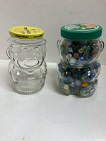 Both character jars side by side, one filled with marbles