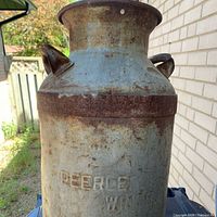 Full view of milk can showing body and embossed branding