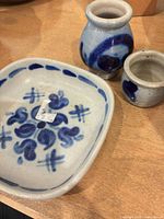 overview of dish, bud vase, small pot showing hand-painted blue motifs