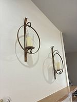 Both wall sconces mounted on wall showing overall design and scale