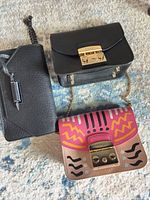 Overview of three crossbody bags on rug