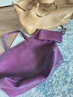 Purple side of tote, tan side displayed, detachable wristlet